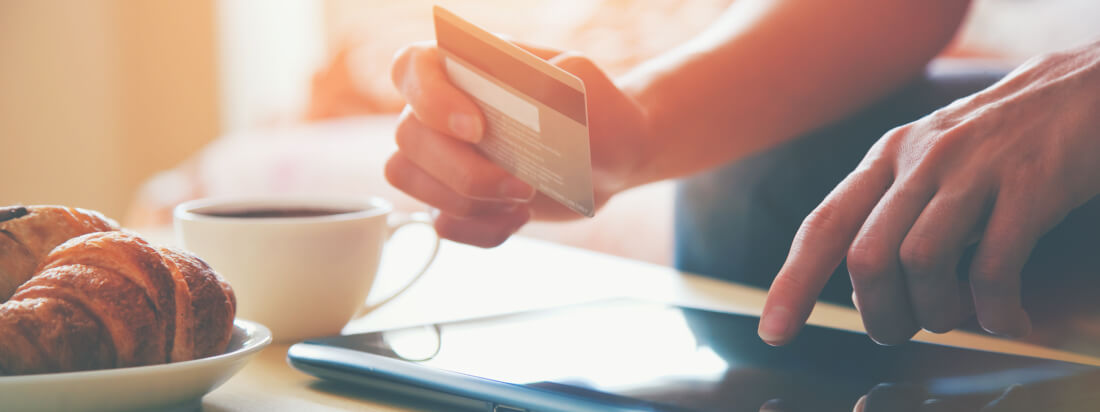 person holding credit card and ipad.