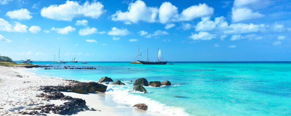 Arashi Beach, Aruba, West Indies: tour boat anchored near the shore for tourists to go swimming or snorkeling in the turquoise water.